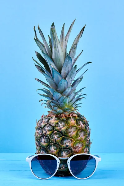 Ananas och solglasögon på blå bakgrund. — Stockfoto