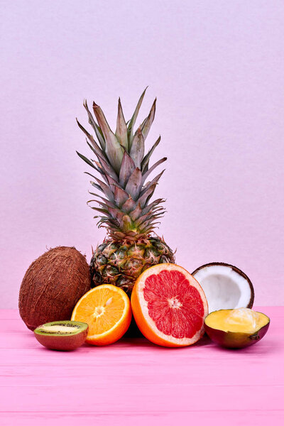 Ассортимент тропических фруктов на розовой поверхности
.