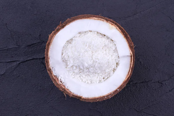 Half of coconut with coconut flakes. — Stock Photo, Image