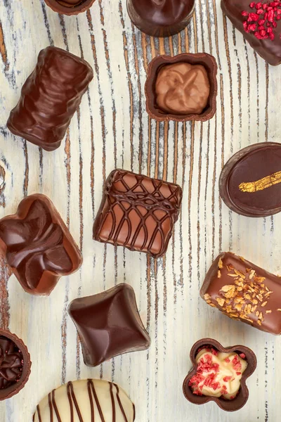 Fundo de madeira com doces de chocolate variados . — Fotografia de Stock