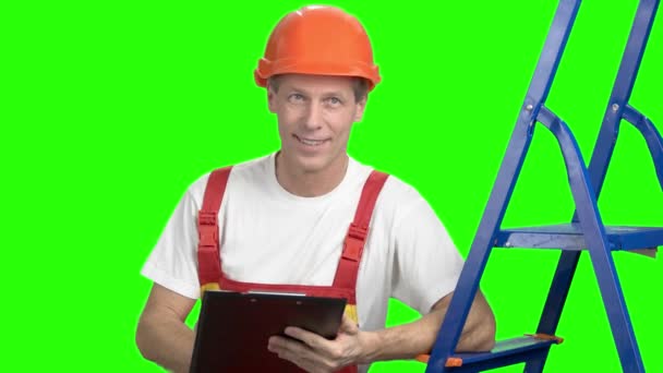 男性建築業者、緑色の画面をクリップボードに書き込む. — ストック動画
