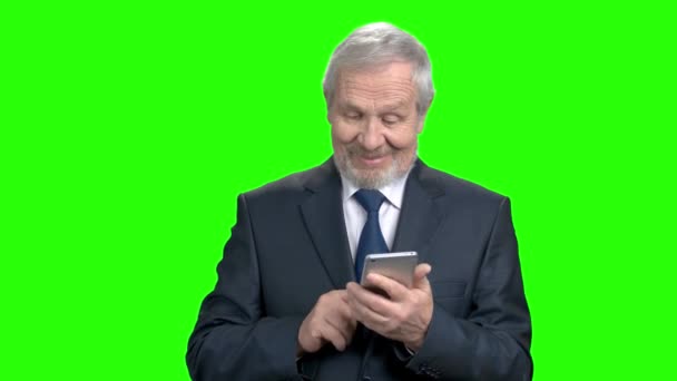 Smiling businessman typing a message on smartphone. — Stock Video