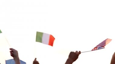 İnsan eli uluslararası bayrakları sallıyor.
