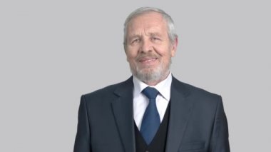 Çapraz kolları olan kendine güvenen üst düzey iş adamı.