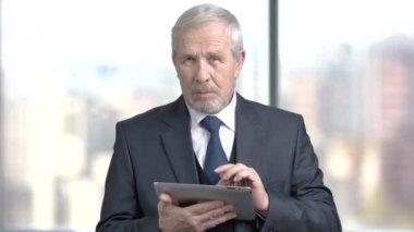 PC tablet üzerinde çalışan ciddi sakallı işadamı.