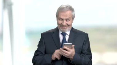 Yaşlı işadamı smartphone, arka plan bulanık kullanarak.
