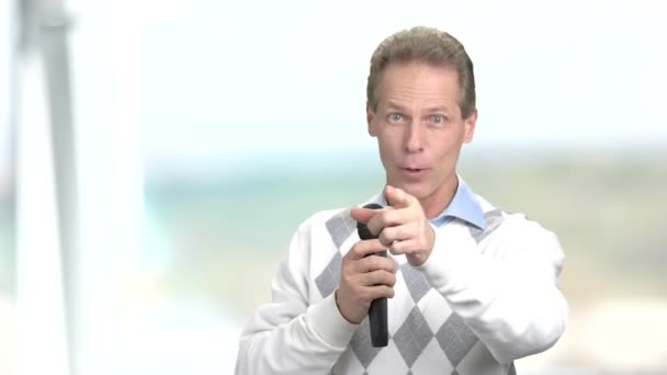 Hombre con micrófono apuntando con el dedo . — Vídeo de stock