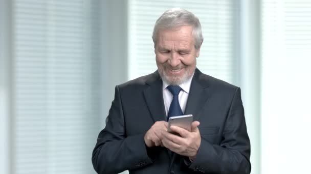 Elderly businessman sending a text message. — Stock Video