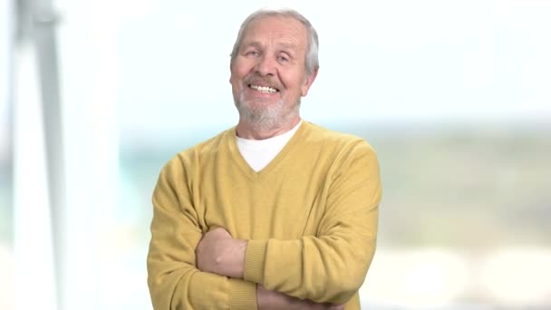 Cheerful elderly man with crossed arms. — Stock Video