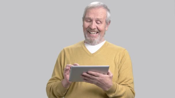 Man met behulp van de tablet pc op grijze achtergrond. — Stockvideo