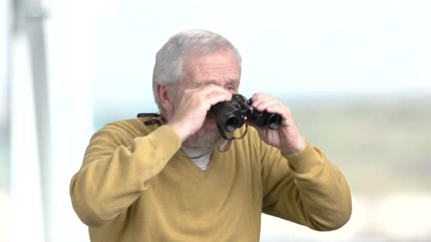 Ηλικιωμένος άνδρας ψάχνει μέσα από κιάλια. — Αρχείο Βίντεο