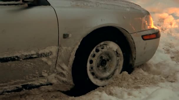 Grijze personenauto vast te zitten in de sneeuw. — Stockvideo