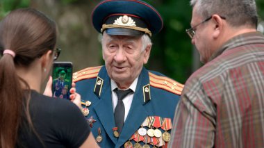 Savaş gazisi üniformalı.