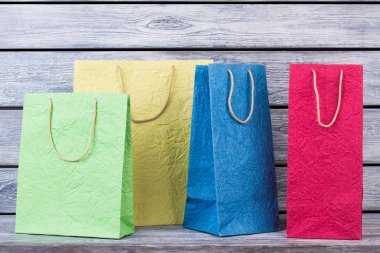 Ahşap arka plan üzerinde renkli alışveriş torbaları topluluğu.