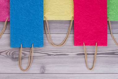 Farklı renkler hediye çanta ahşap arka plan üzerinde.