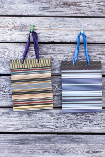 Bolsas de regalo de papel colgadas de alambre con pinzas de ropa . — Foto de Stock