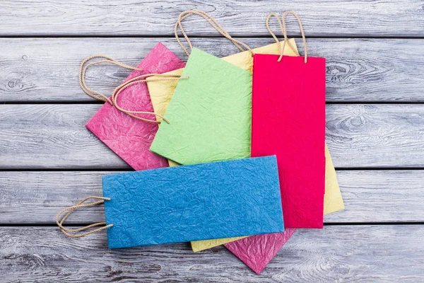 Assorted shopping bags on wooden background. — Stock Photo, Image