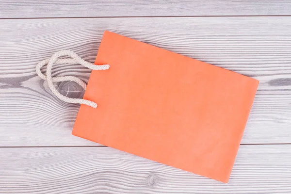Κενό πορτοκαλί τσάντα για ψώνια σε φόντο ξύλινη. — Φωτογραφία Αρχείου