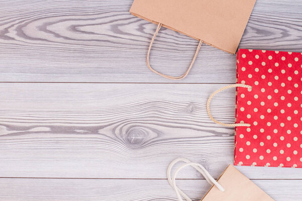 Kraft paper shopping bags on wooden background.