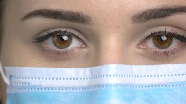 Екстремальні крупним планом коричневі очі з медичною маскою . — стокове відео