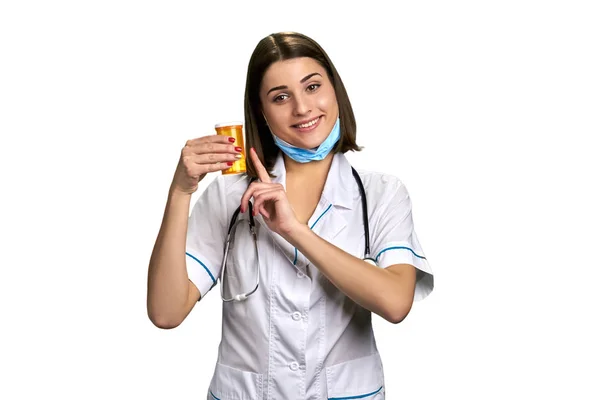 Smiling woman doctor with pills.