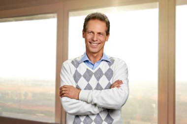 Çapraz kolları olan mutlu olgun adam.