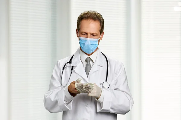 Доктор одягає гумову рукавичку . — стокове фото