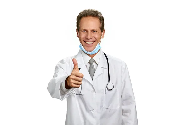 Médico sonriente haciendo gestos con el pulgar hacia arriba . — Foto de Stock