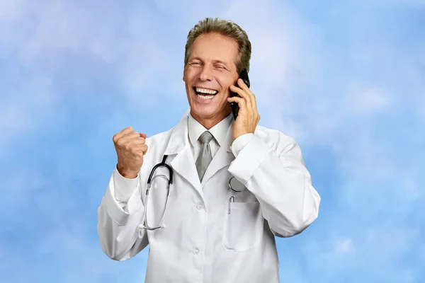 Ενθουσιασμένος ο γιατρός μιλάει στο κινητό τηλέφωνο. — Φωτογραφία Αρχείου