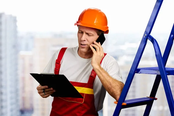 Construction worker talking on smartphone. — Stock Photo, Image
