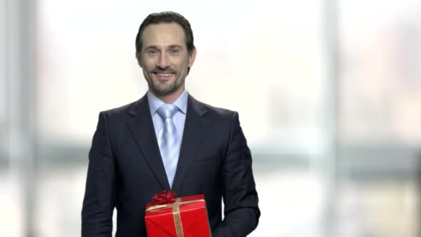 Bonito homem apresentando caixa de presente . — Vídeo de Stock