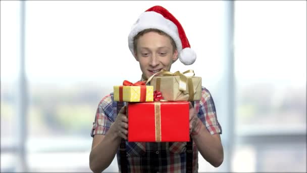 Christmas pojke med presentaskar på suddig bakgrund. — Stockvideo