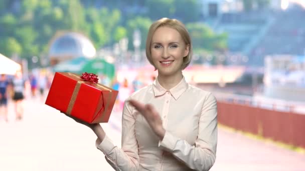 Портрет улыбающейся женщины с подарочной коробкой. — стоковое видео