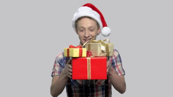 Niño en sombrero de Navidad dando cajas de regalo. — Vídeos de Stock