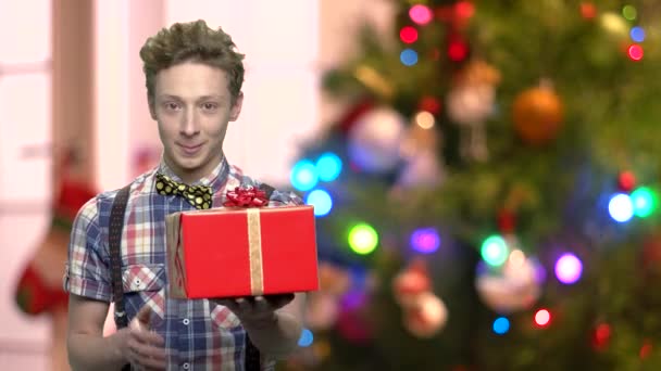 Niño con caja de regalo sobre fondo borroso de Navidad . — Vídeo de stock