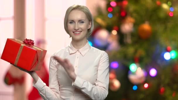 Frau präsentiert Weihnachtsgeschenkschachtel. — Stockvideo