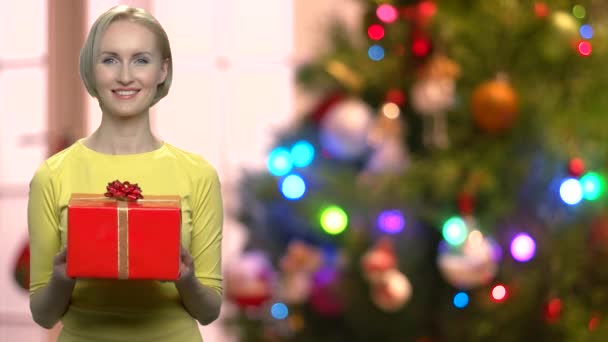 Kvinna med presentask på suddig jul bakgrund. — Stockvideo