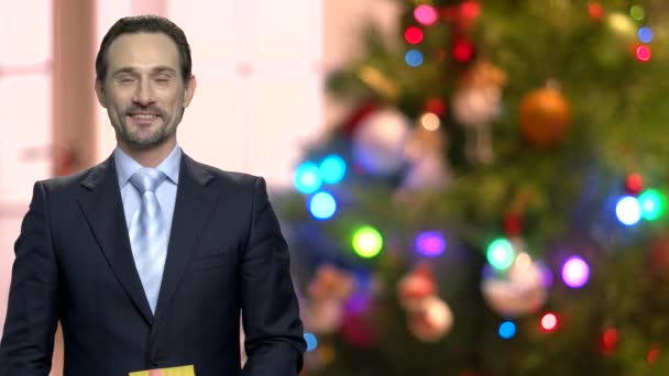 Hombre de negocios guapo sosteniendo regalo de Navidad . — Vídeo de stock