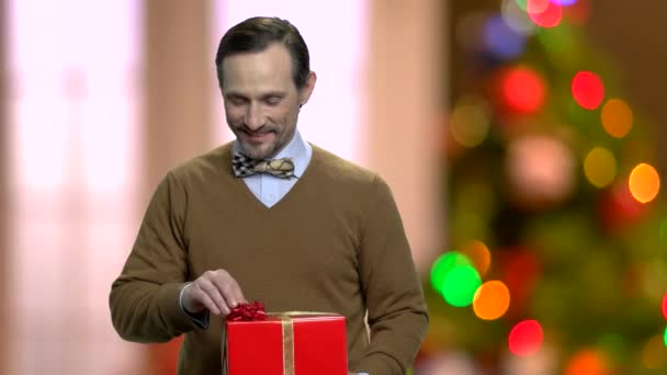 Hombre con hermosa caja de regalo en el fondo de Navidad . — Vídeos de Stock