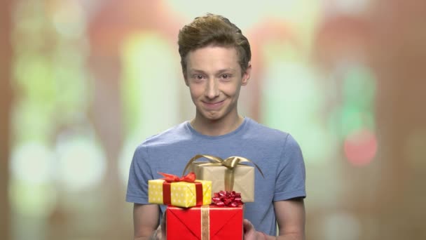 Teenager-Junge überreicht Geschenkboxen. — Stockvideo