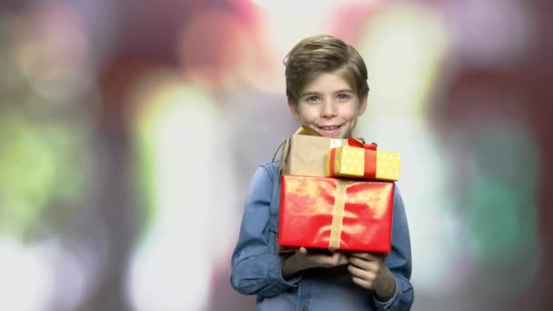 Hübsches Kind mit Geschenkschachteln. — Stockvideo