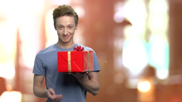 Knappe tiener jongen met geschenkdoos. — Stockvideo