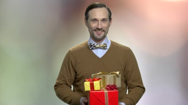Aantrekkelijke man met geschenkdozen. — Stockvideo