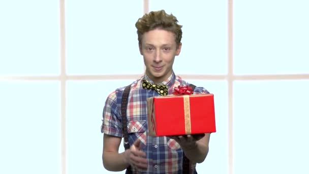 Glimlachend jongen geven geschenkdoos met lint. — Stockvideo