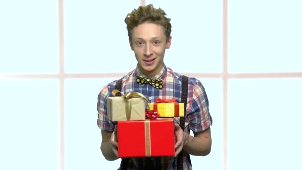 Adolescente menino segurando pilha de presentes . — Vídeo de Stock