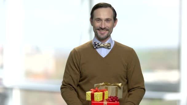 Porträt eines gutaussehenden Mannes, der Geschenkboxen schenkt. — Stockvideo