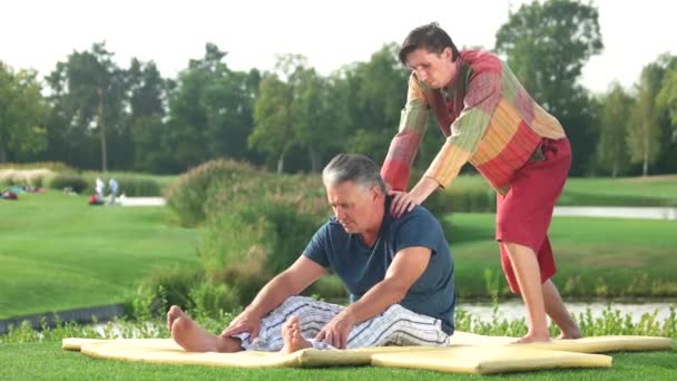 Unga terapeut gör Thaimassage till mogen man. — Stockvideo
