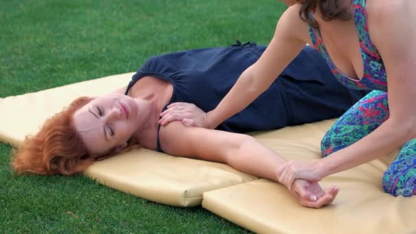 Кавказка практикует тайский массаж на открытом воздухе . — стоковое видео