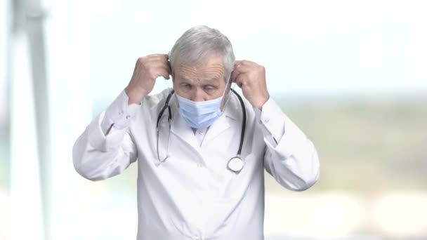 Médico senior poniéndose máscara protectora . — Vídeo de stock