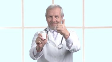 Başparmak ile neşeli kıdemli doktor.